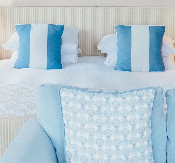 white and blue pillows beside brown table lamp in a Modern Coastal Bedroom