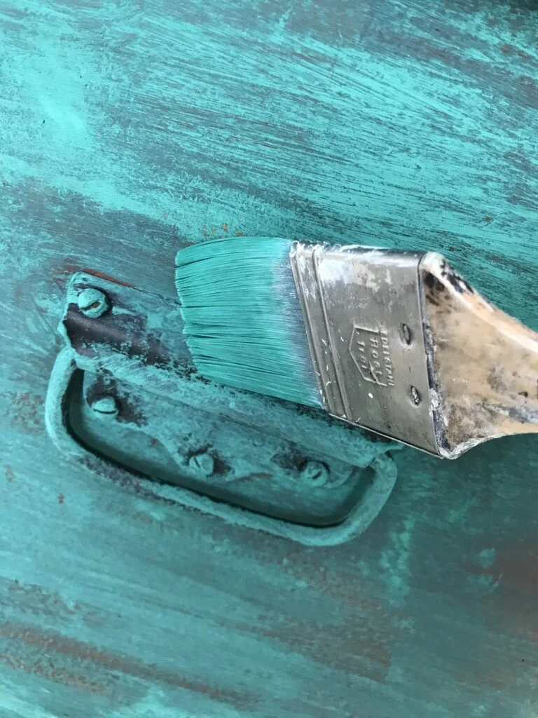 Brush painting a drawer with blue paing