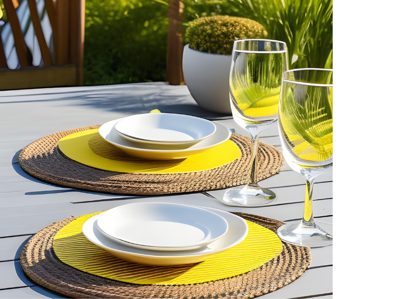 Coastal Yellow Patio Dining Set, cord place mats in yellow and natural color, 2 glasses for wine, white vase and white plates.