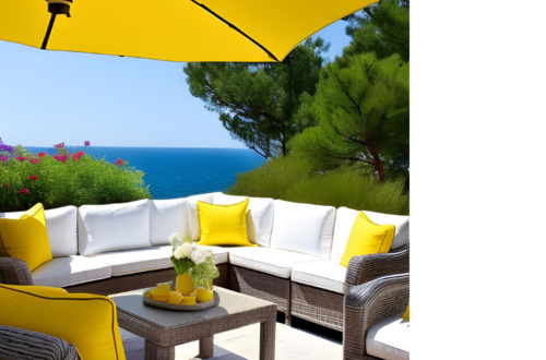 A patio with a view to the ocean and pine trees, a set of rattan sofas and coffee table with white cushions and yellow throw pillows, a yellow umbrella, and yellow decor on a tray on the coffee table