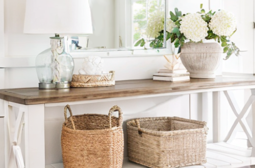 Coastal Entryway with glass table lamp, ceramic vase, white mirror, baskets and rattan tray